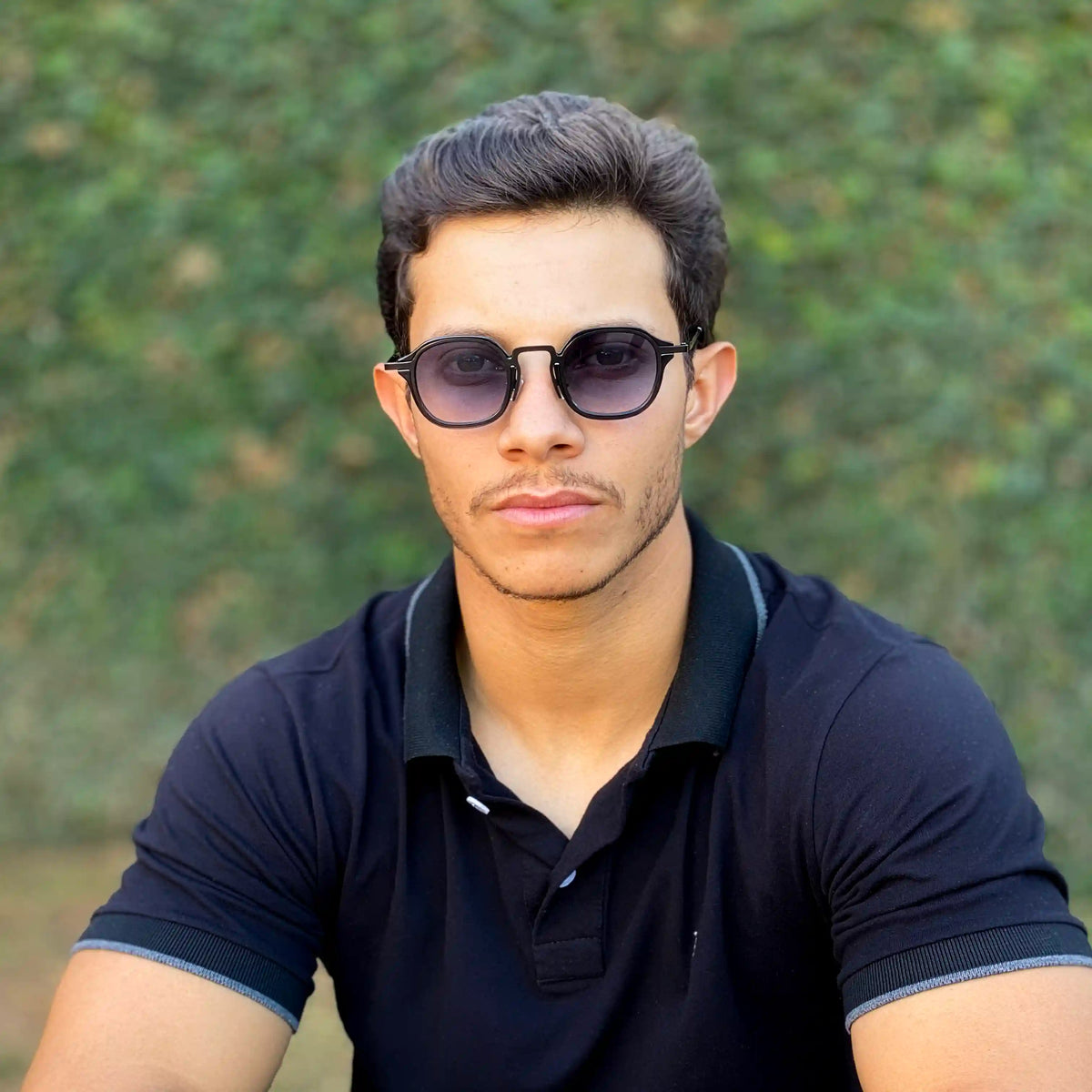 Óculos de sol masculino com armação redonda de metal preto e lentes escuras com proteção UV400.
